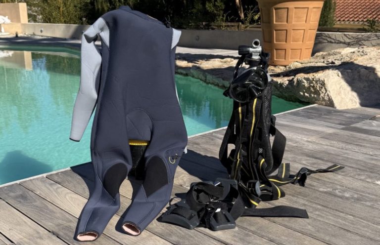 Équipements de plongée, y compris une combinaison et des bouteilles, près d'une piscine.  
