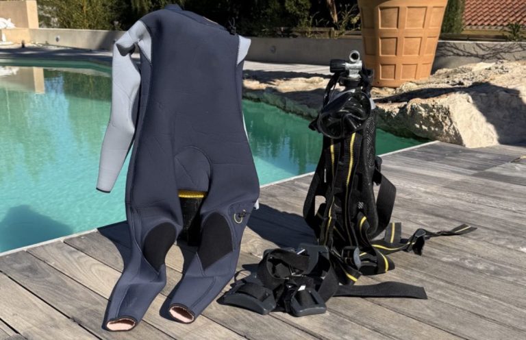 Équipements de plongée, y compris une combinaison et des bouteilles, près d'une piscine. 