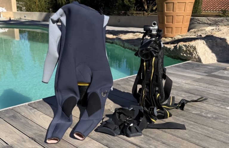 Équipements de plongée, y compris une combinaison et des bouteilles, près d'une piscine. 