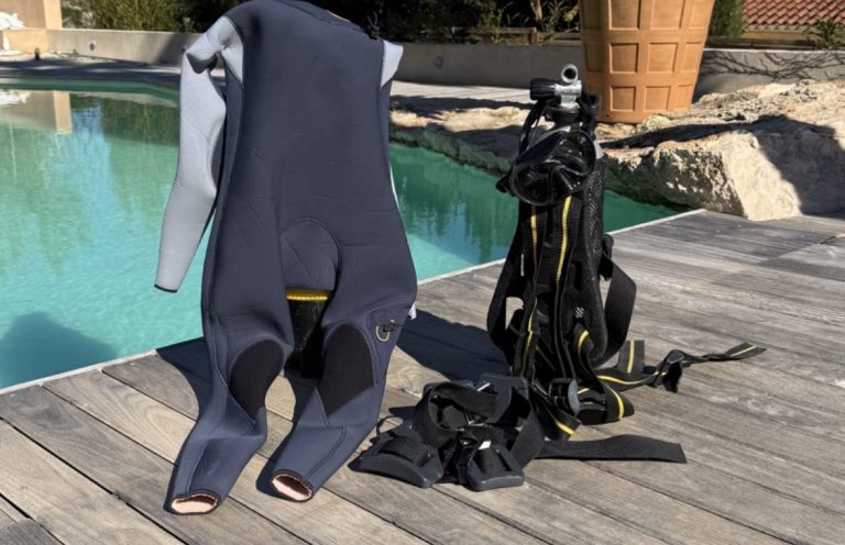 Équipements de plongée, y compris une combinaison et des bouteilles, près d'une piscine.  